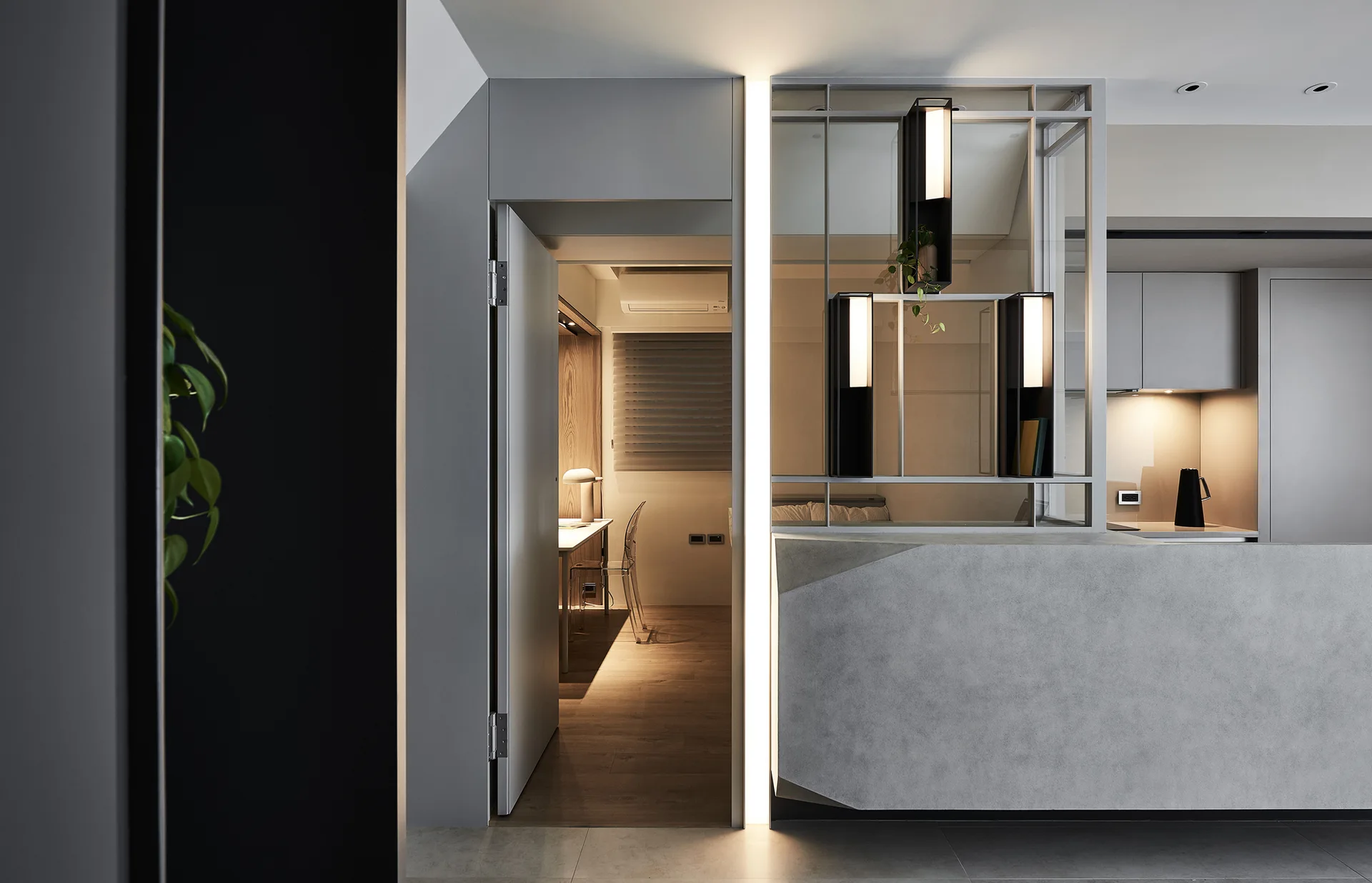 A modern grey interior features an open doorway with an integrated vertical LED light strip next to a geometric metal partition wall.