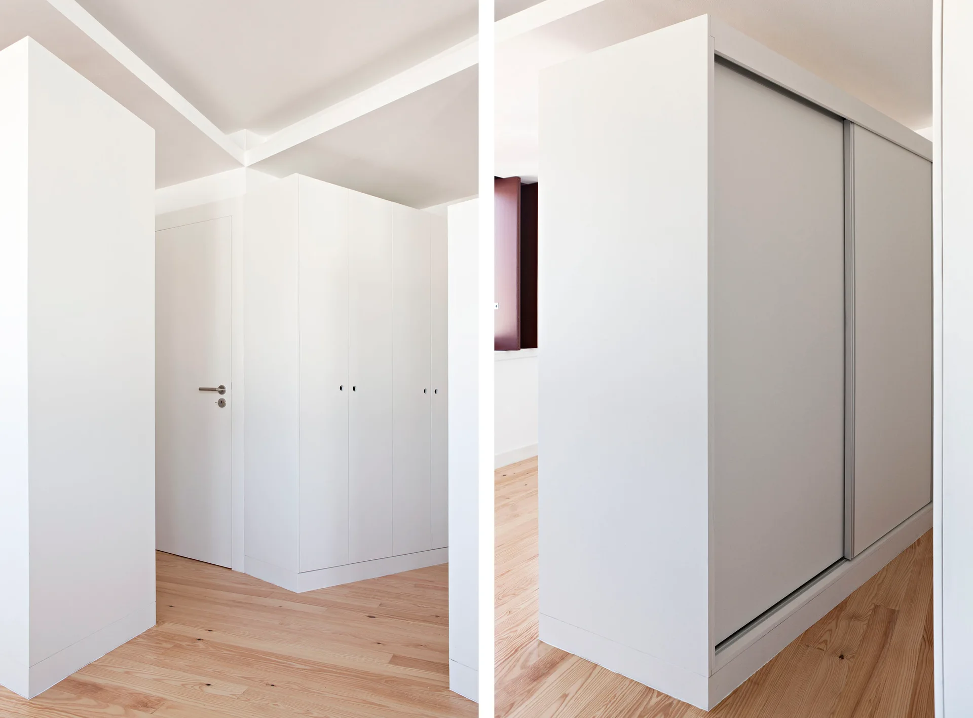 A minimalist interior featuring white built-in wardrobes and matching doors installed over light-toned wood plank flooring.