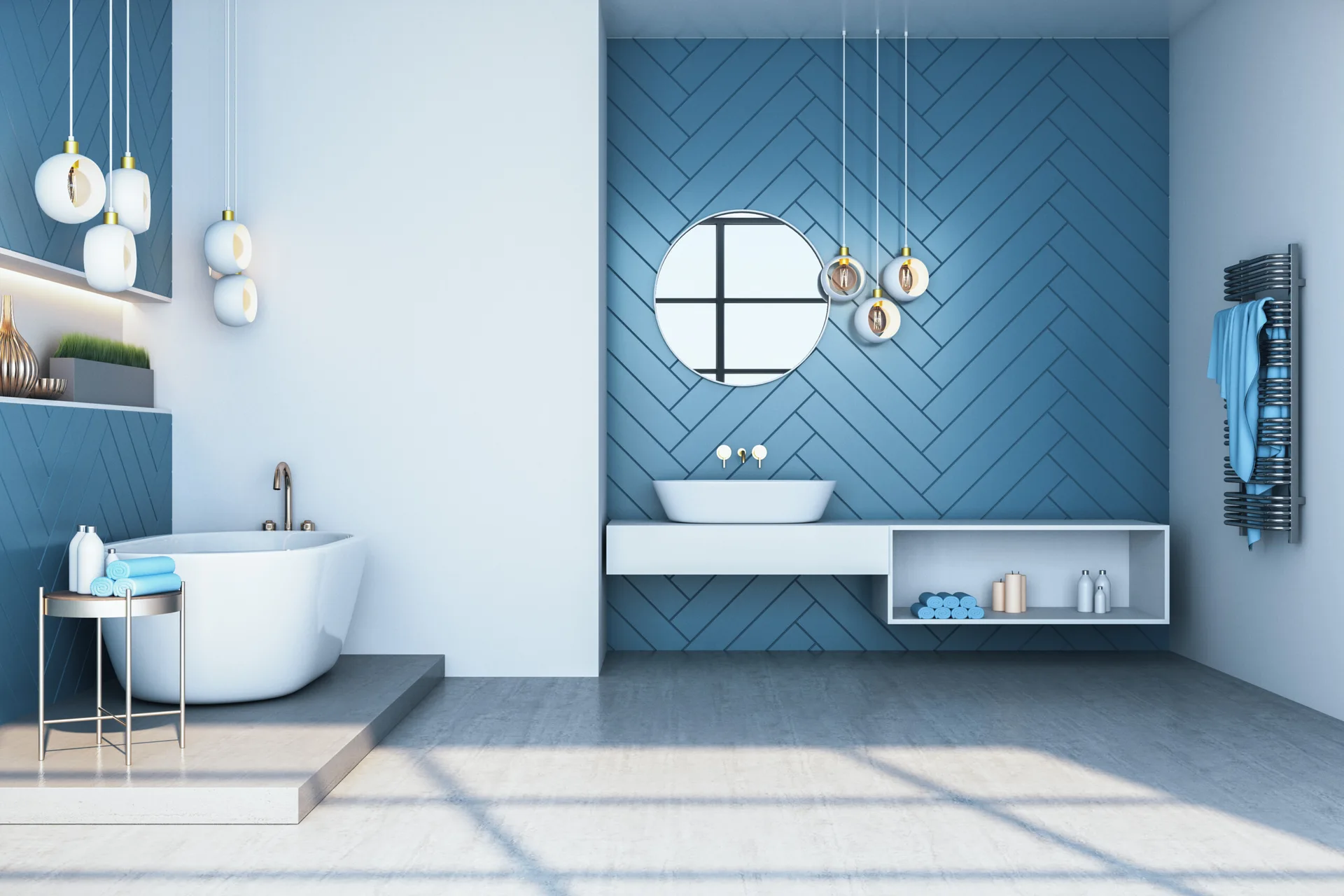 A modern bathroom featuring blue herringbone tiled walls, a freestanding white bathtub on a grey platform, a floating vanity, and round mirror.